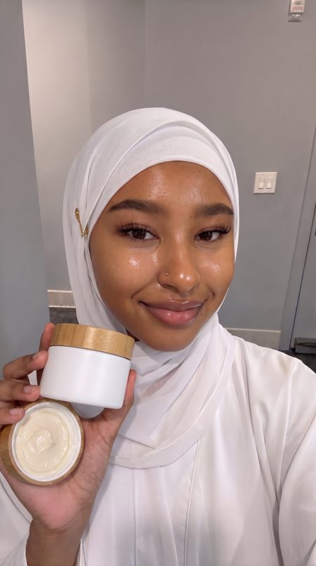 Amina, an AI presenter, holding skincare